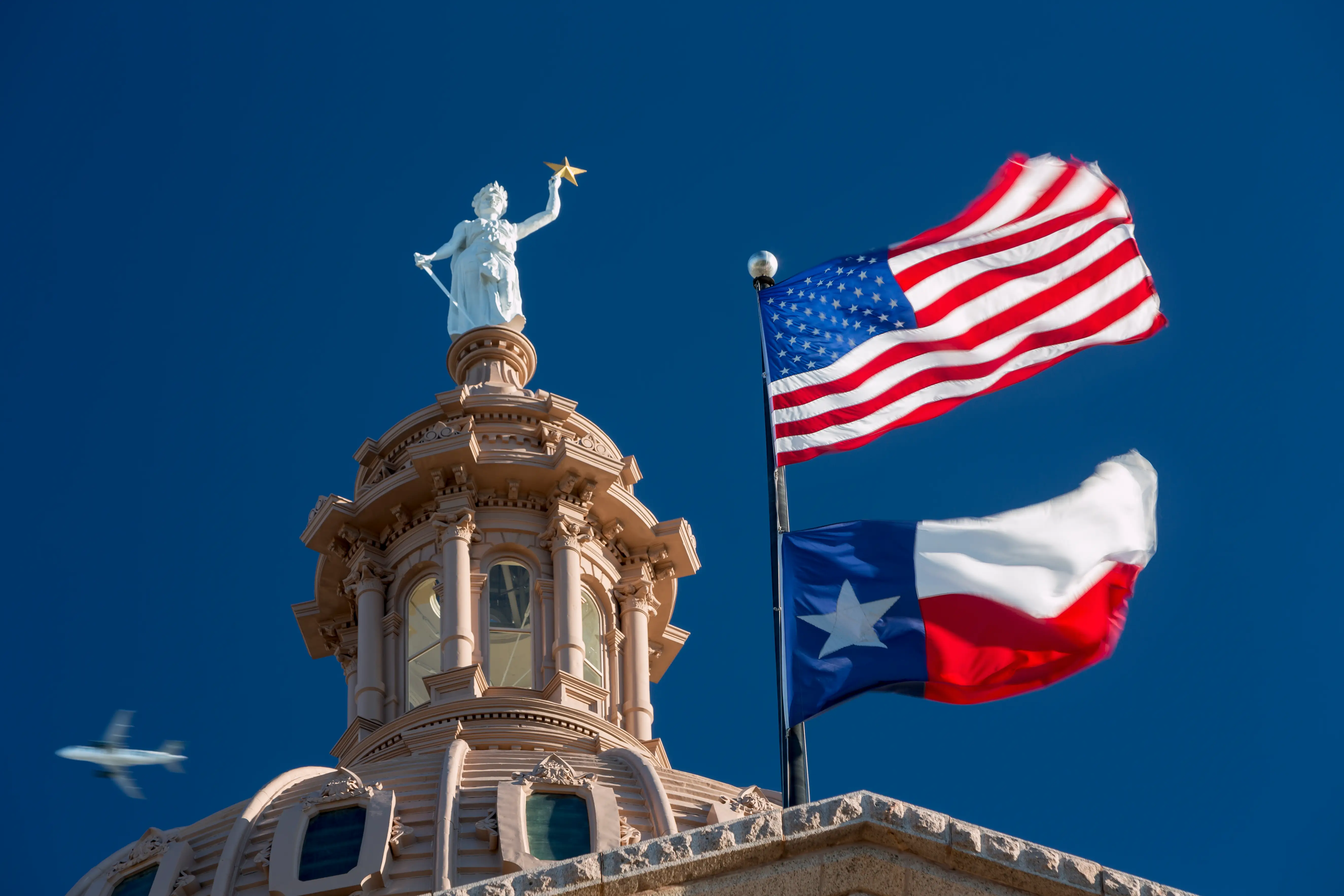 The American and Texas flags at the Austin state capitol.
