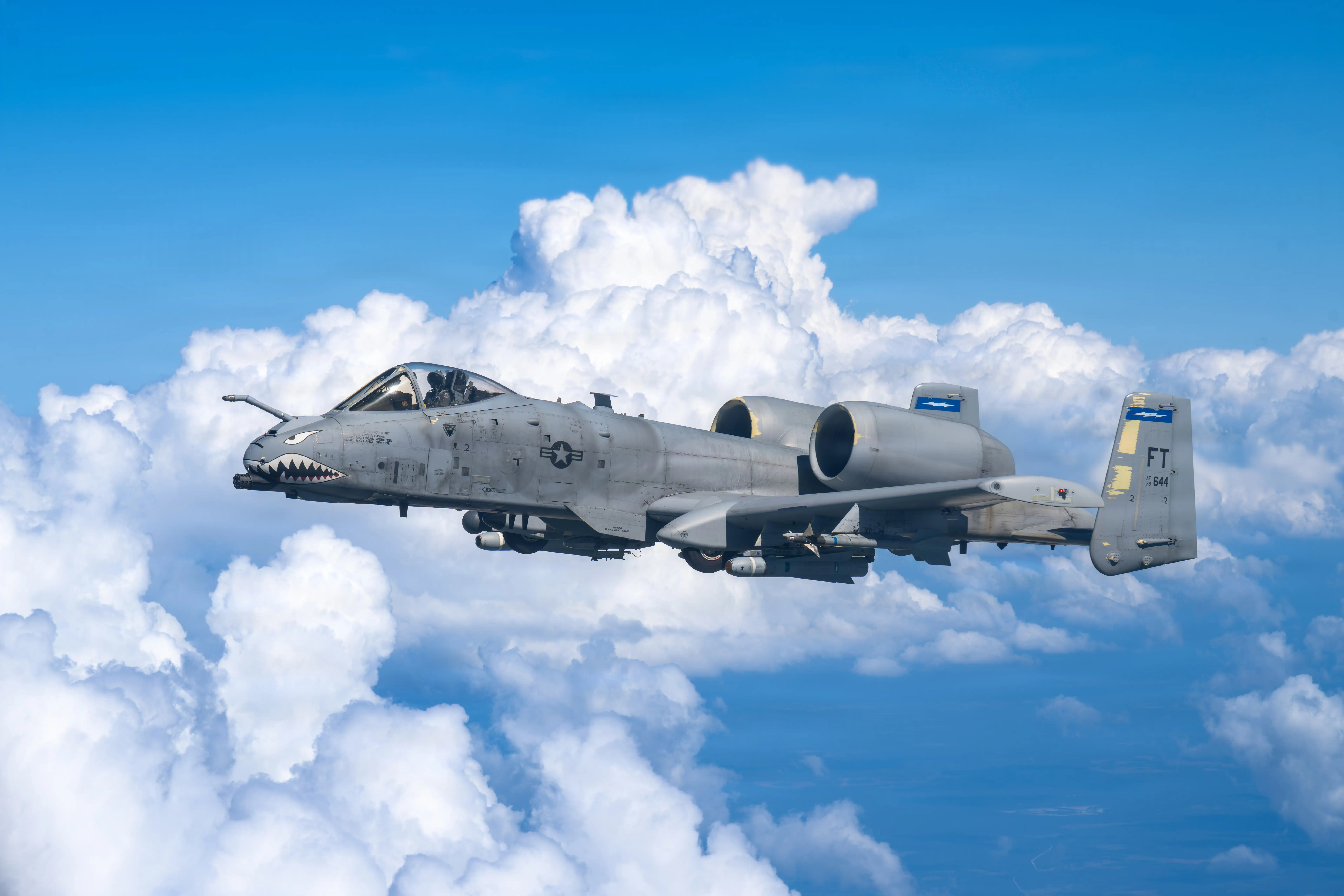 An A-10 Thunderbolt II flies in a cloudy sky.