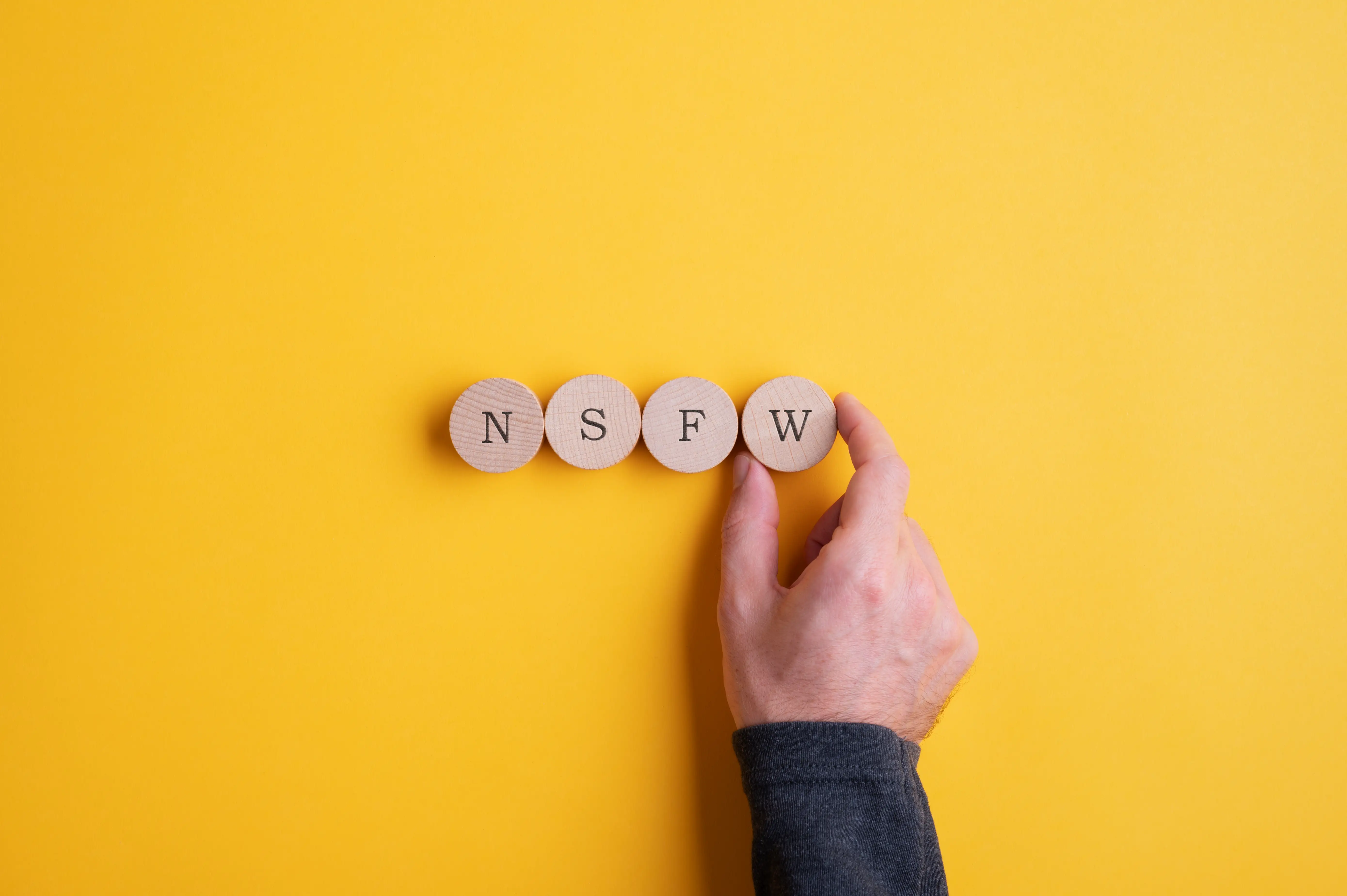 The word NSFW spelled out in circular wooden blocks