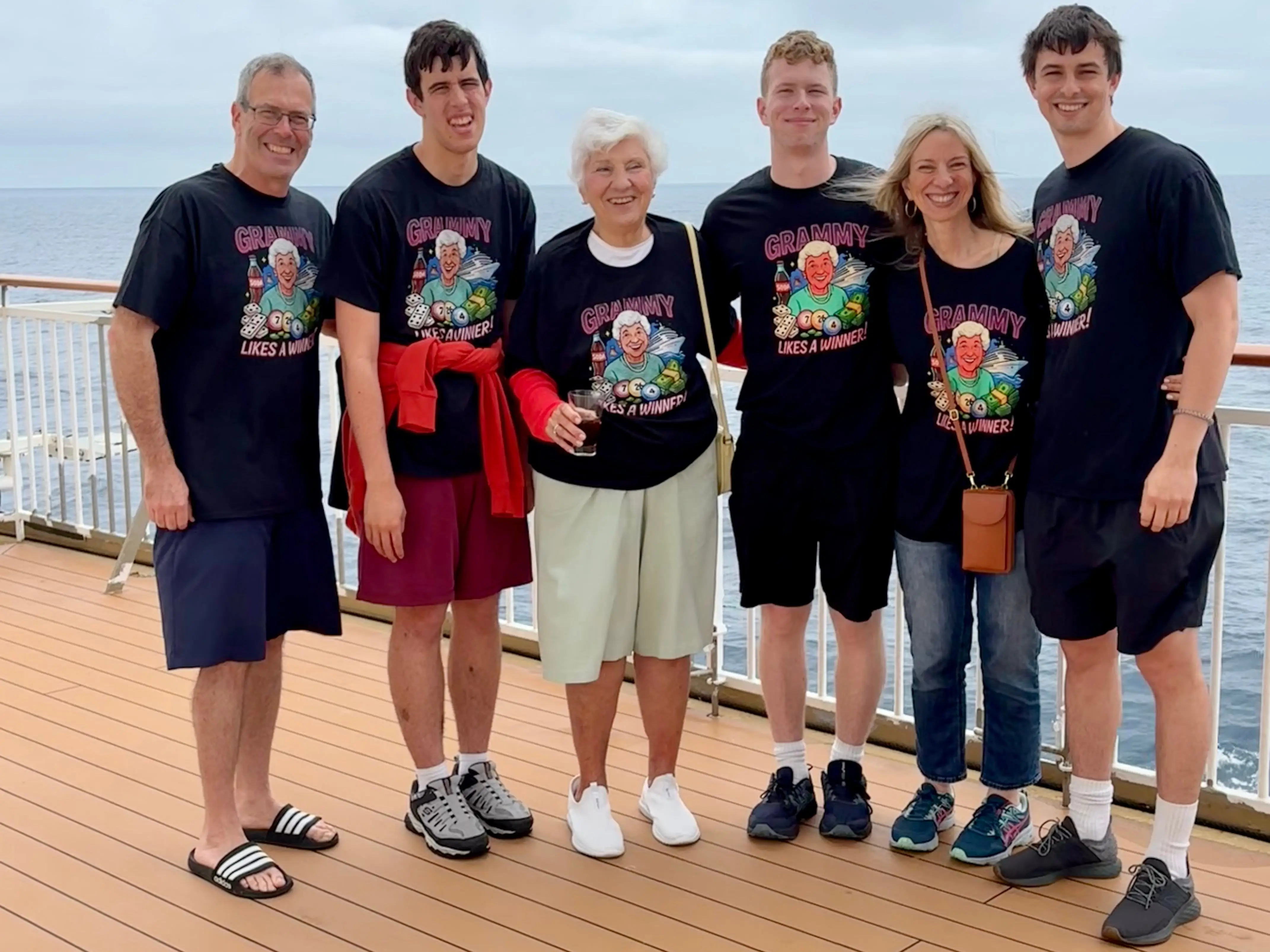 The author (fifth from the left) poses with her huhsband, mother, and three sons while on a cruise.
