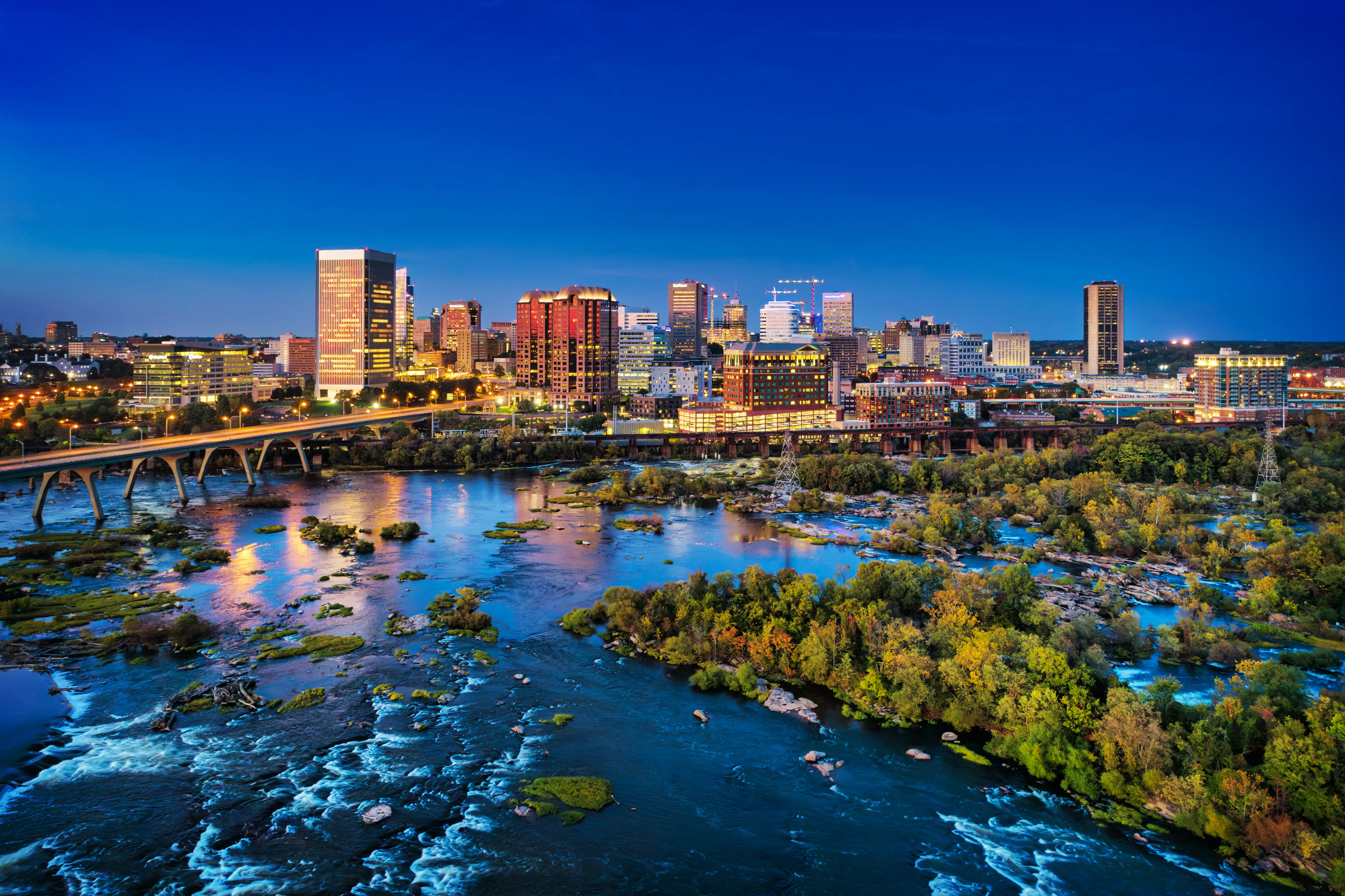 Downtown Richmond skyline aerial with the James River, rapids, and islands in the foreground.