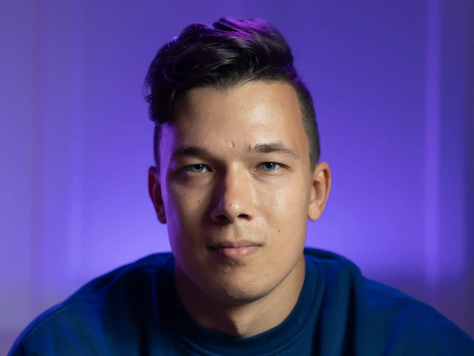 headshot of a man with a purple background