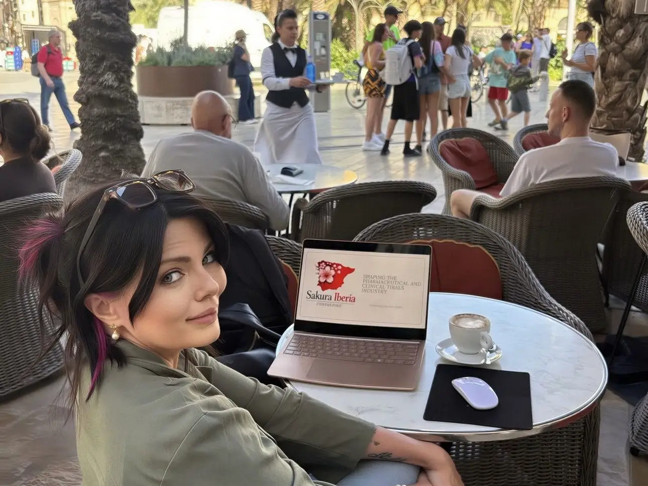 A woman with a laptop sitting in a café in Spain.