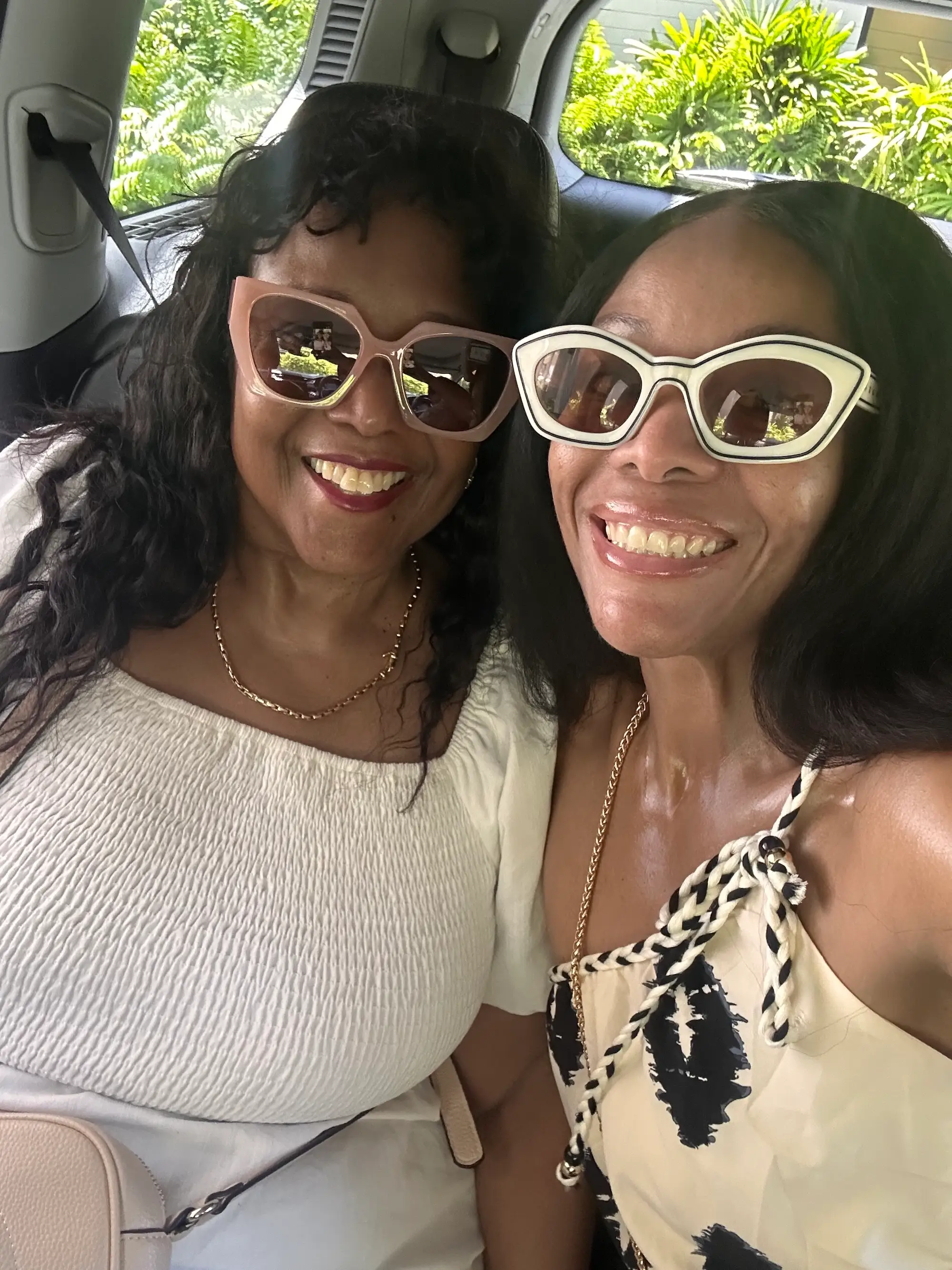 Author Kimberly Wilson and her mother smiling in the backseat of a car. They're both wearing sunglasses.