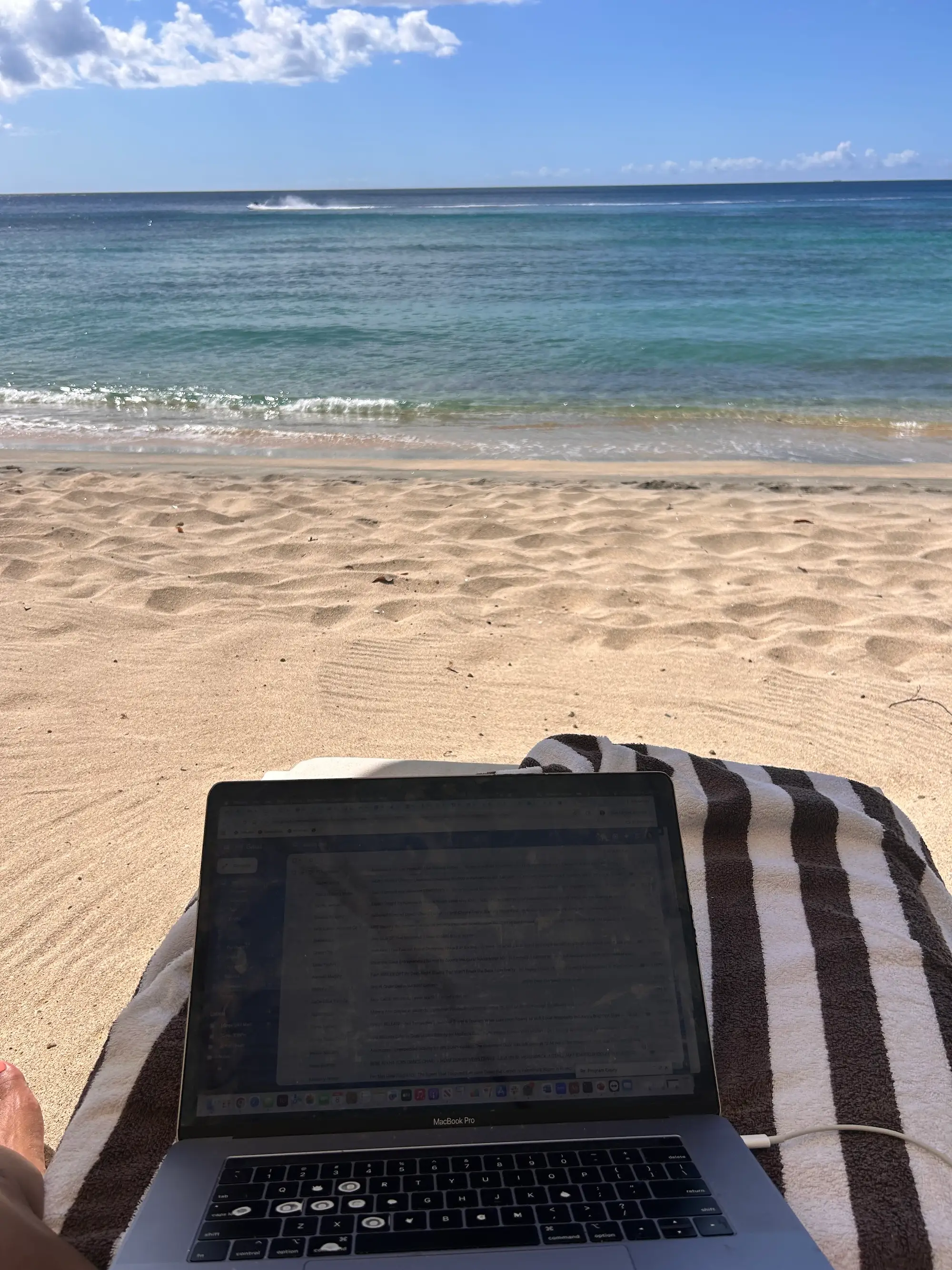 A laptop on a beach chair at the beach.