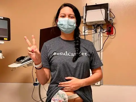A woman in a mask and shirt that reads 