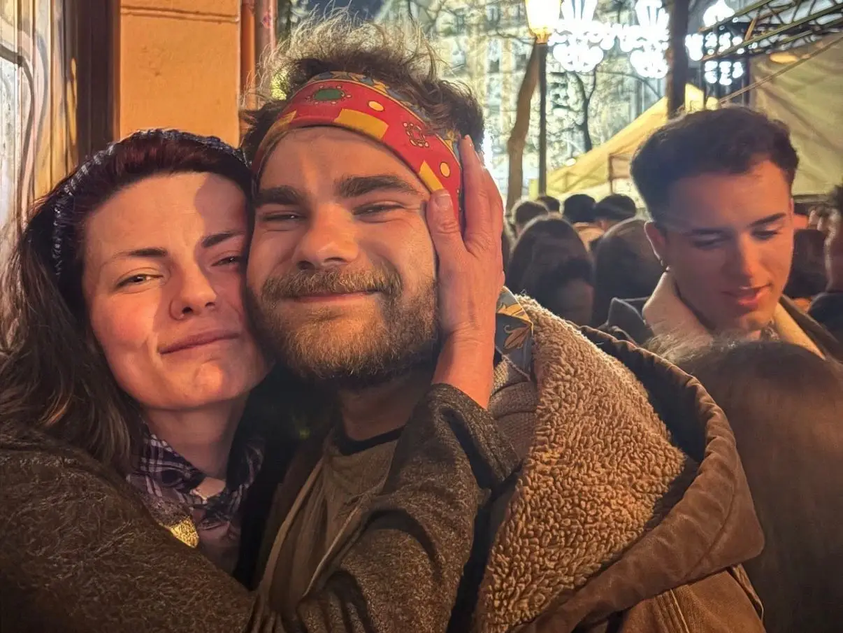 A mom hugging her son in a street