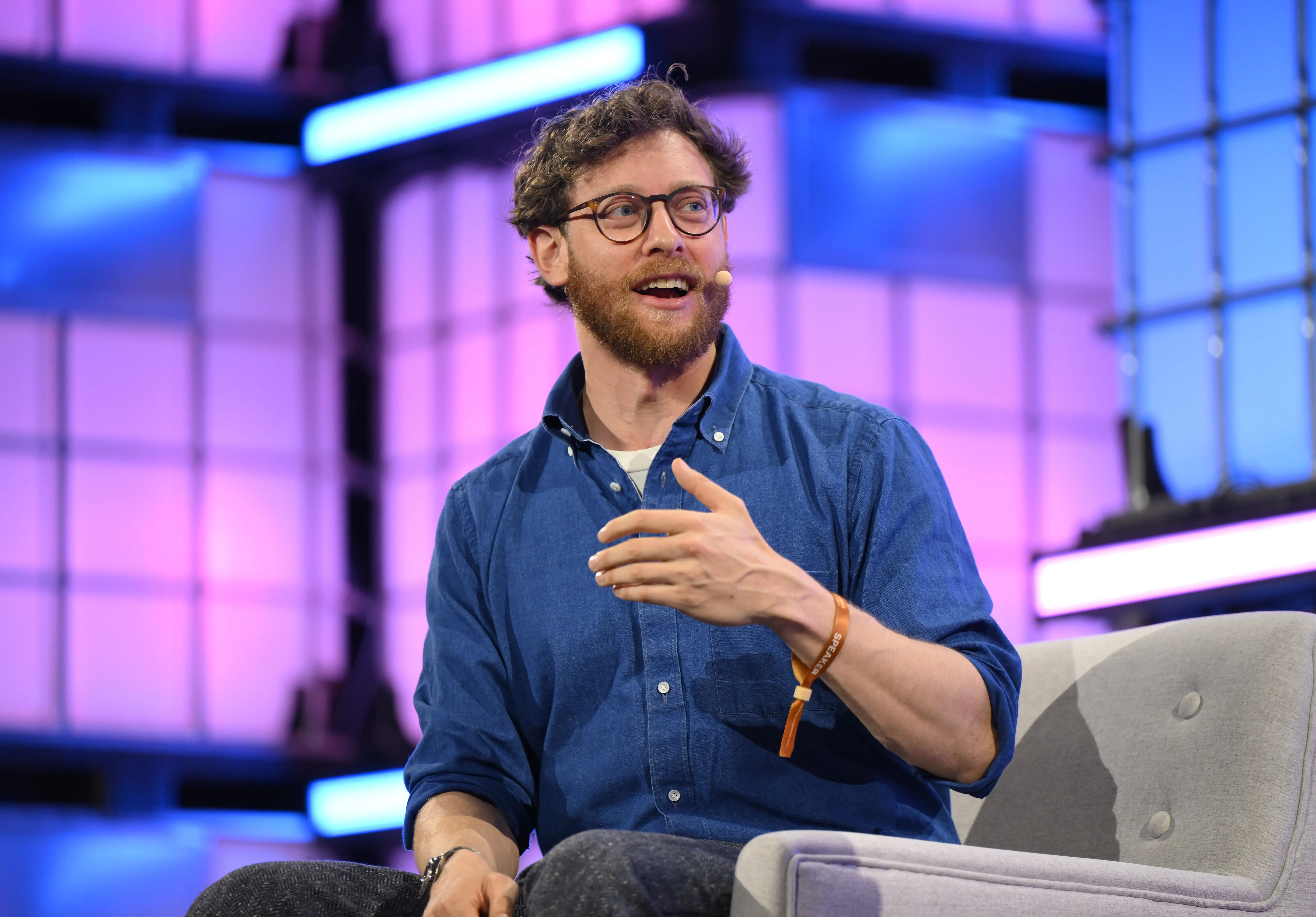 Dan Shipper, dressed in a blue jean button-down, talks onstage.