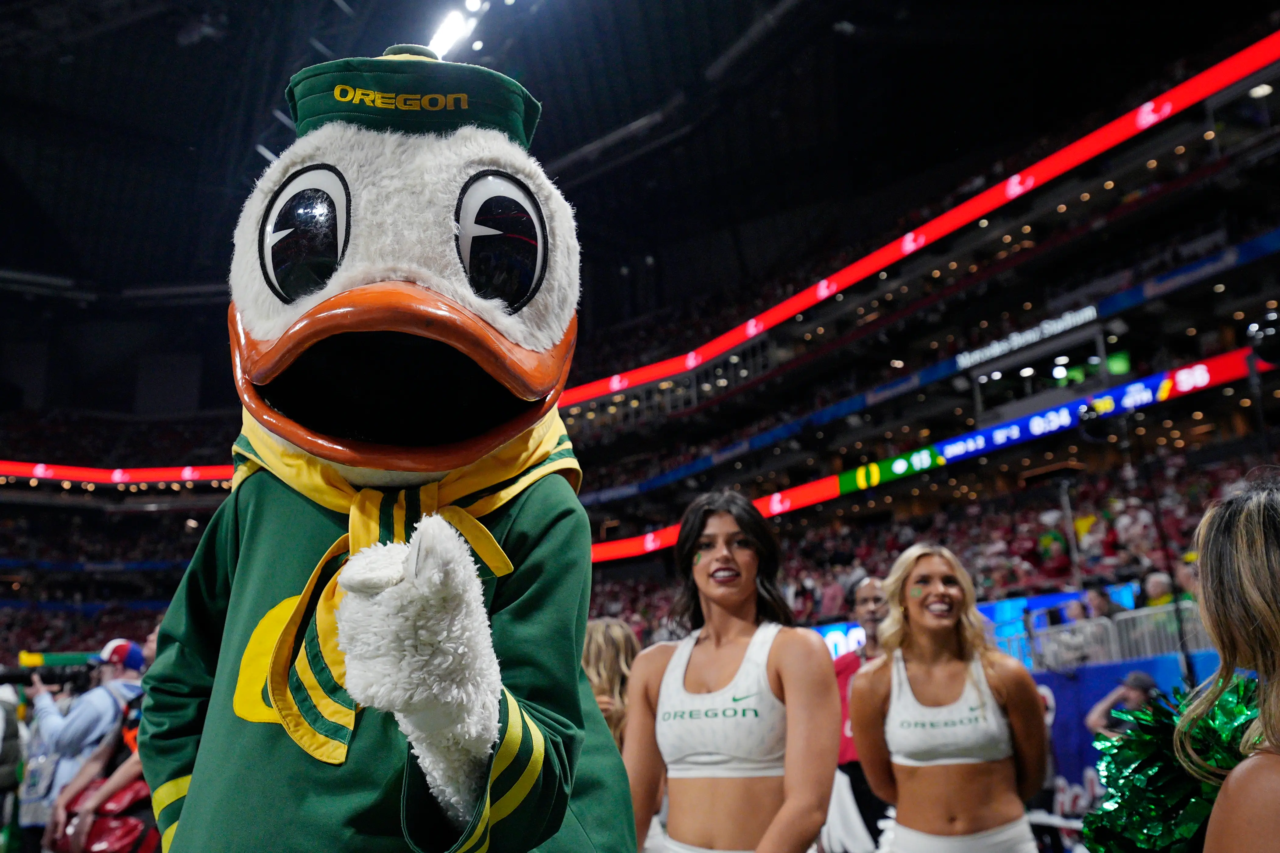 Oregon Ducks mascot The Oregon Duck stands on the sideline with cheerleaders during the College Football Playoff Semifinal at the Chick-fil-A Peach Bowl against the Indiana Hoosiers on January 09, 2026 at Mercedes-Benz Stadium in Atlanta, Georgia.