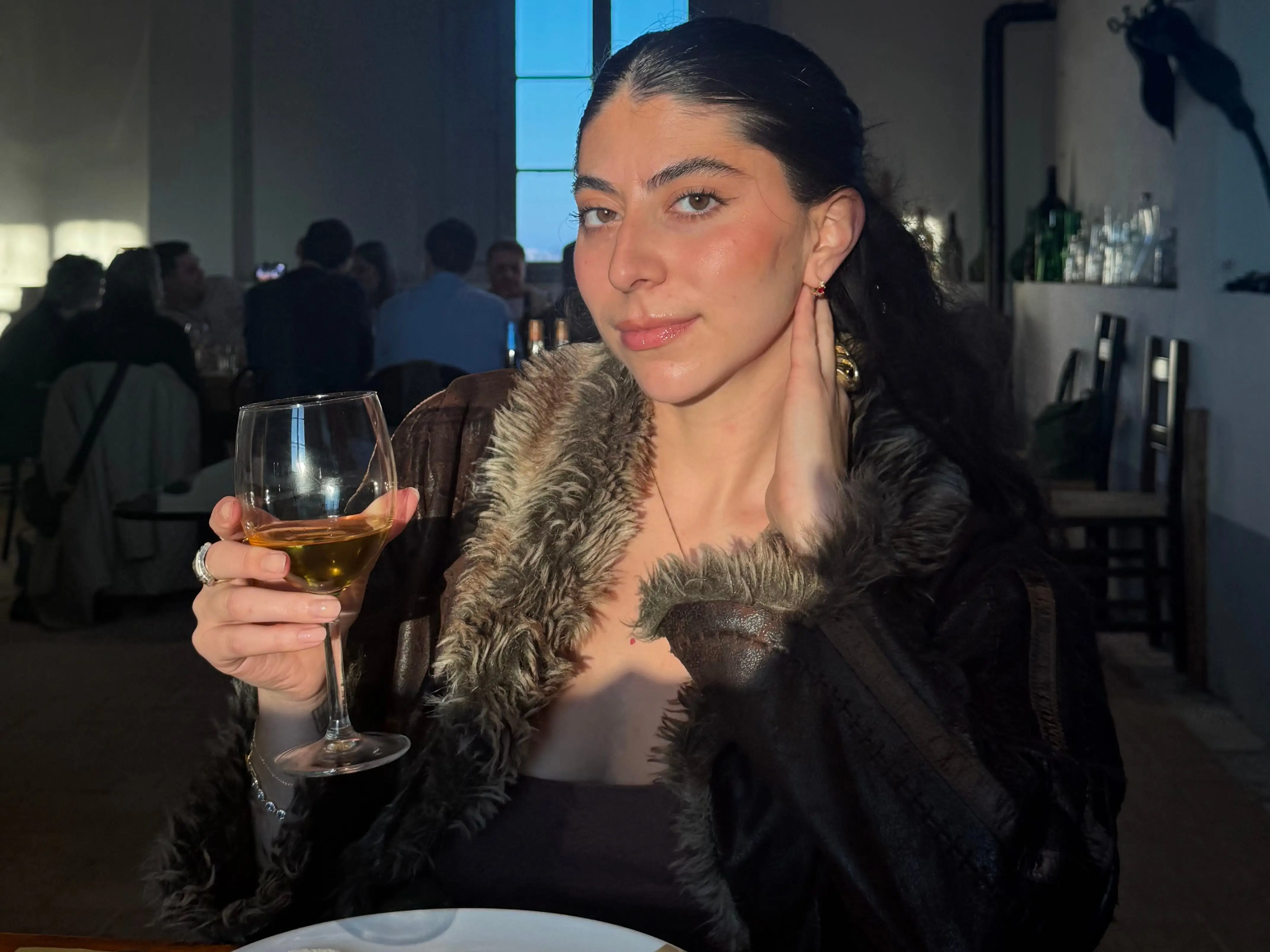 Justine Golata with glass of wine in restaurant