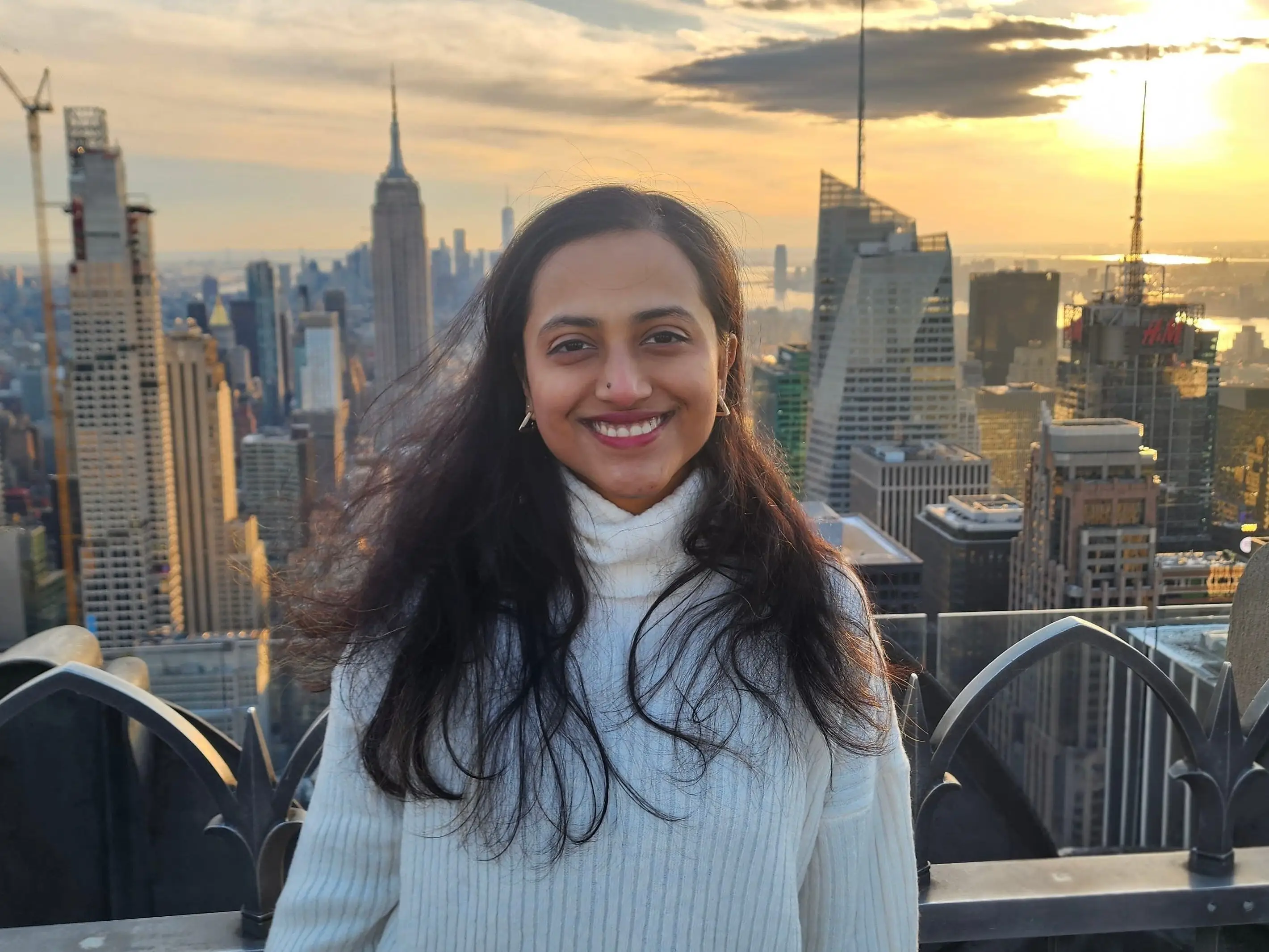 Sunjana Ramana standing in front of the New York skyline. The Empire State building is visible behind her.