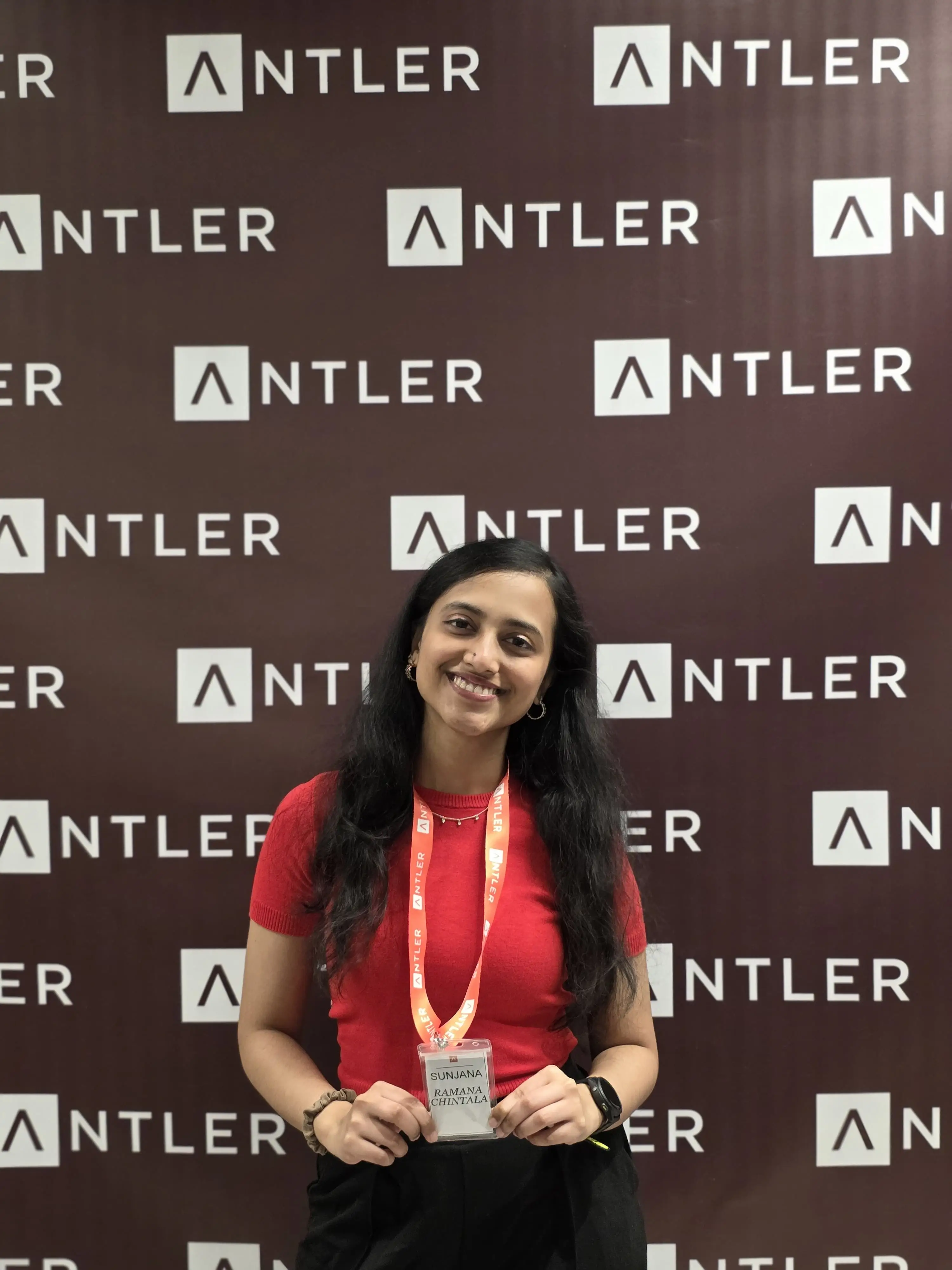 Sujana Ramana standing in front of a backdrop with the Antler logo on it.