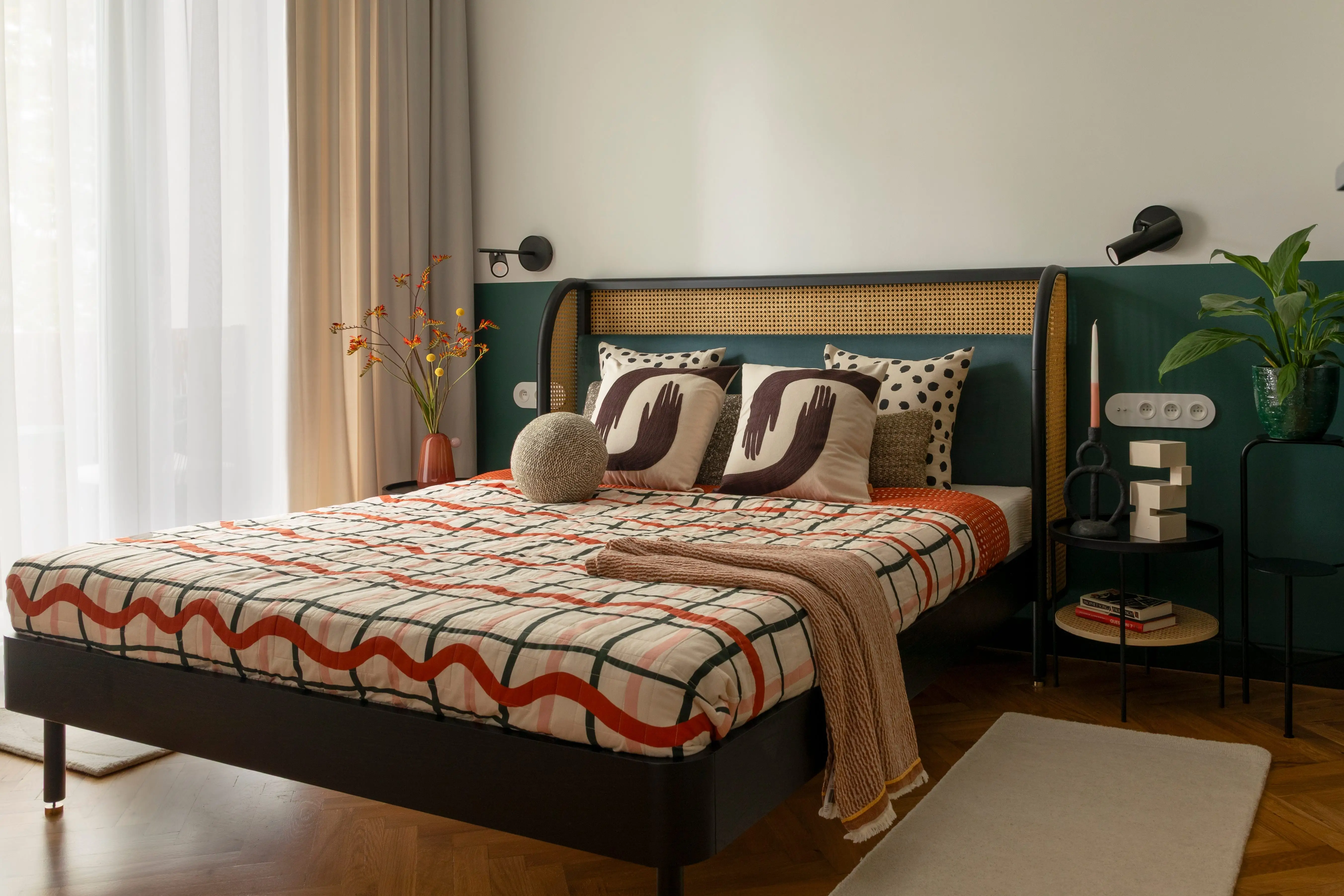 Bedroom with teal beadboard, patterned bedding and pillows, simple overhead lamp,