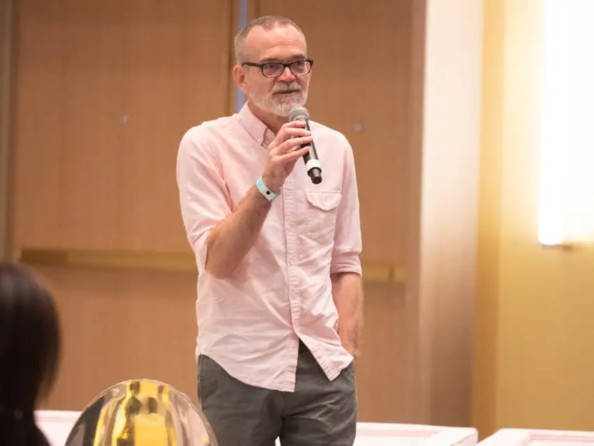 Bil Browning speaking at a live event with microphone