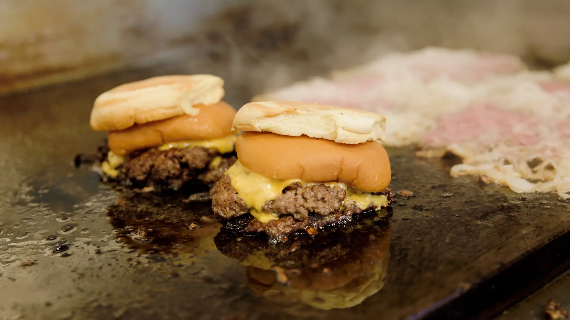Hamburgers cooking on a stove.