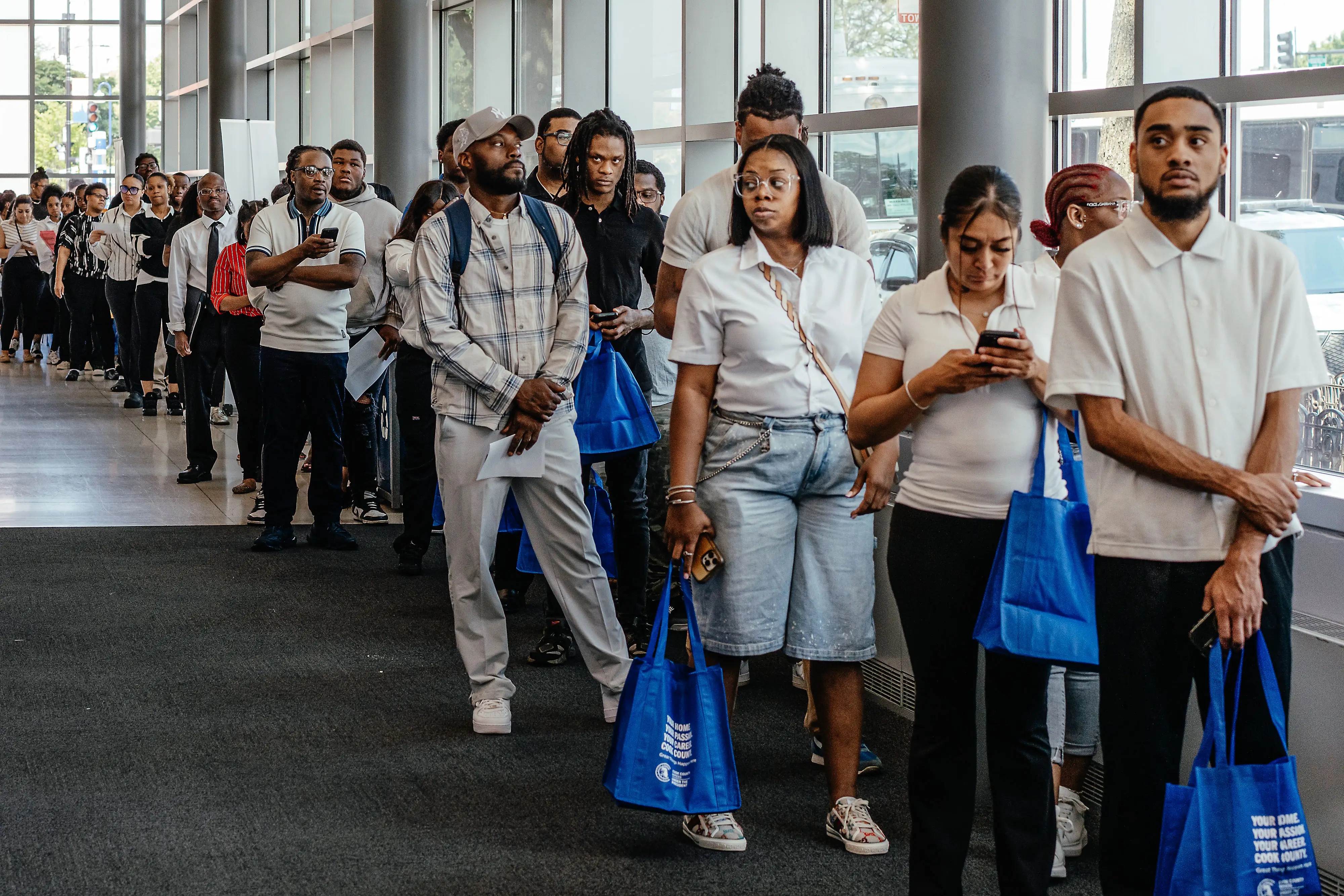 Job seekers wait in line to enter an auditorium for a job fair hosted by the Cook County government to support federal workers in Chicago, Illinois, US, on Thursday, June 26, 2025.