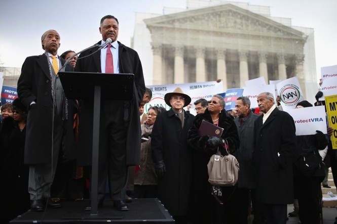 Photograph of Rev. Jesse Jackson and Rev. Al Sharpton at a podium outside the Supreme Court building. A crowd of people, mostly African-American, gather to listen.