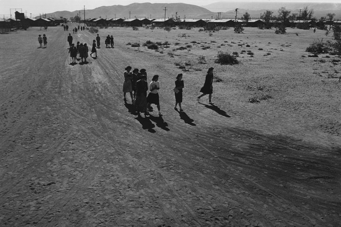 People walk in an open field in a black and white image