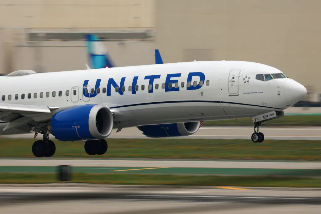 United Airlines Boeing 737 MAX 8 airplane landing on a runway.