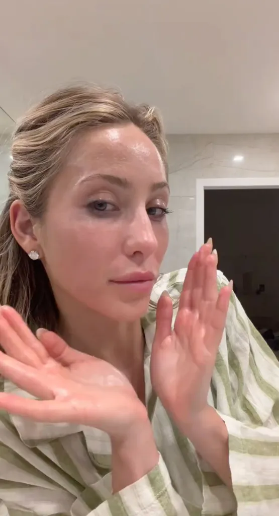 Alix Earle applying skincare to her face.