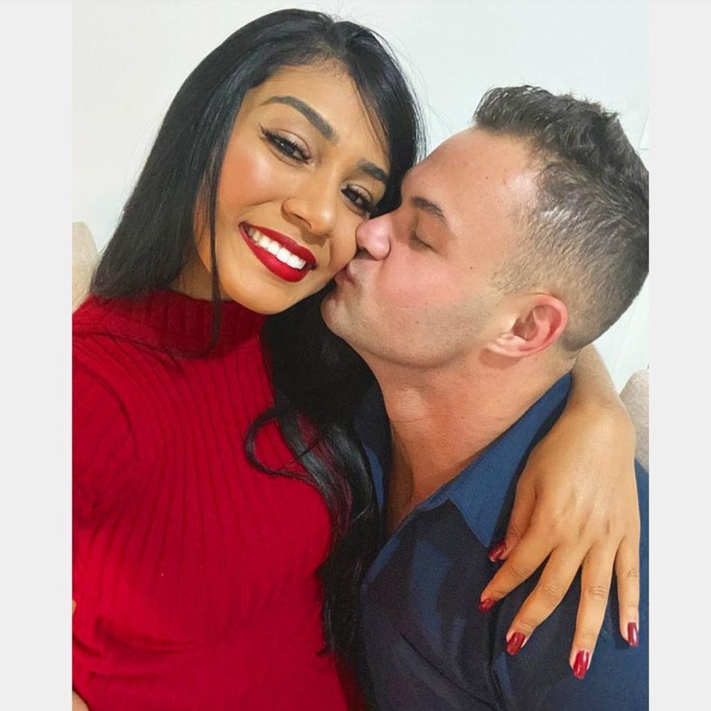 Patrick Mendes kissing Thais Ramone on the cheek.