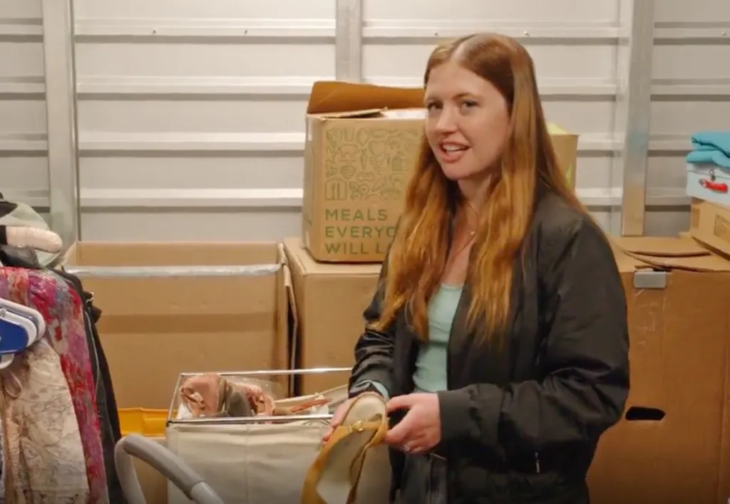 Catie holding a shoe in a storage unit.