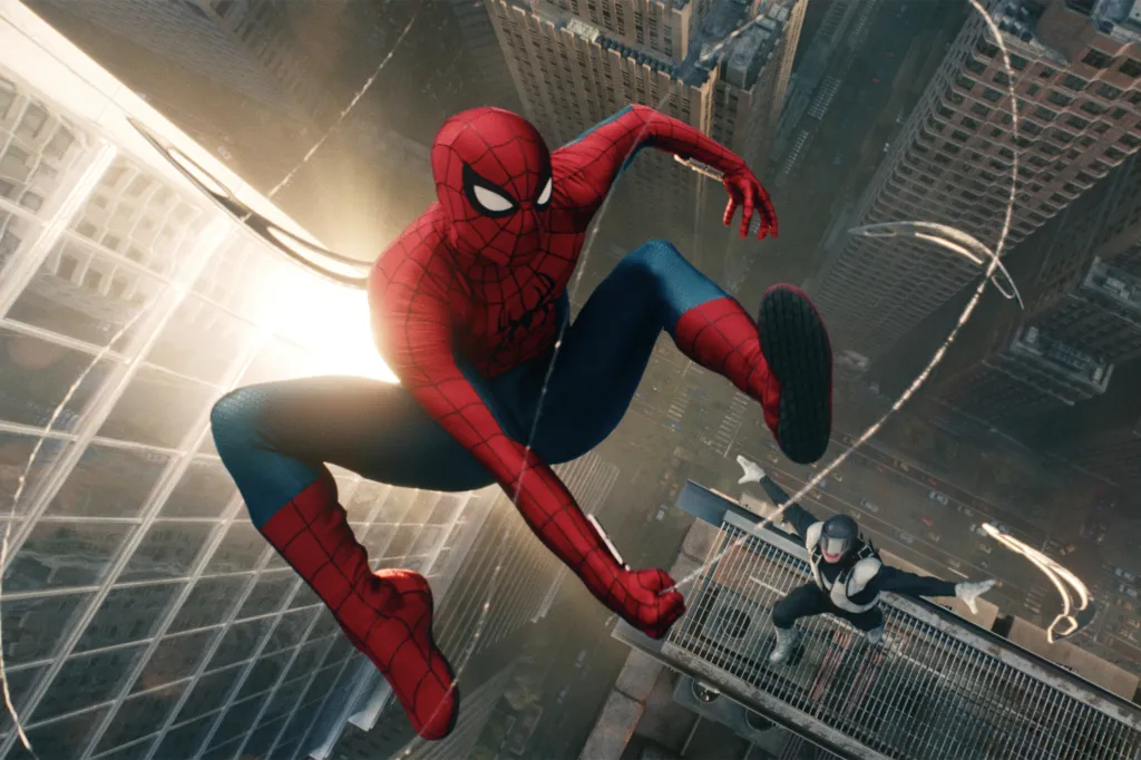 Spider-Man in his red and blue suit, surrounded by spider webs, as he hangs high above a city with tall buildings, with a villain in a black and white suit looking up at him from a ledge.