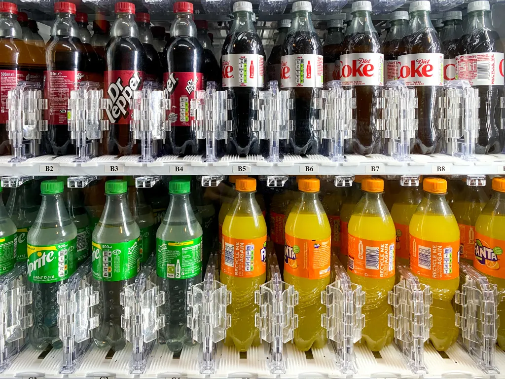 Bottles of carbonated drinks for sale in a vending machine.