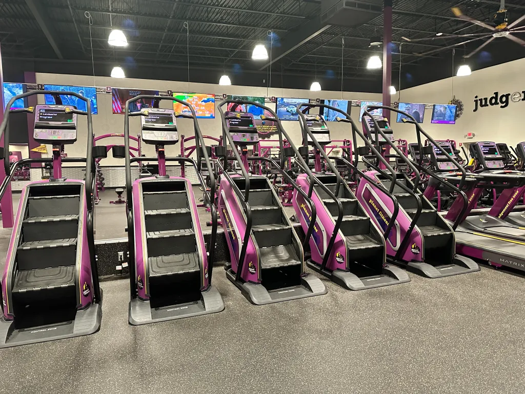 View of Stairmaster and cardio equipment inside a Planet Fitness gym.