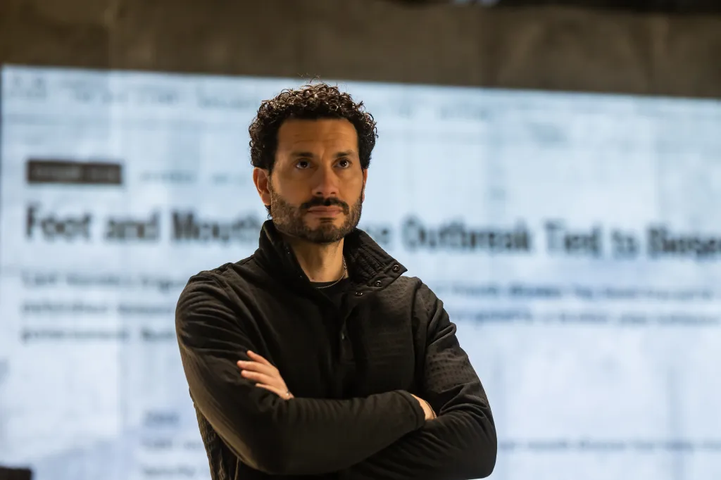 Andrew with arms crossed in an operations center.