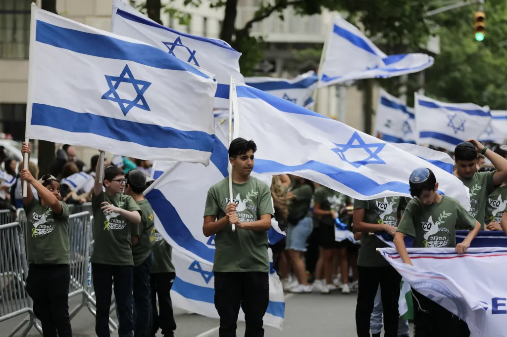 Participants wave Israeli national flags as they march during the Israel Day Parade on May 18, 2025 in New York City.