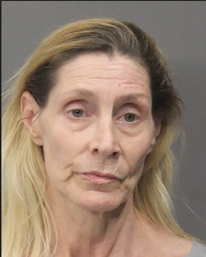 A woman with long blonde hair and a gaunt face.