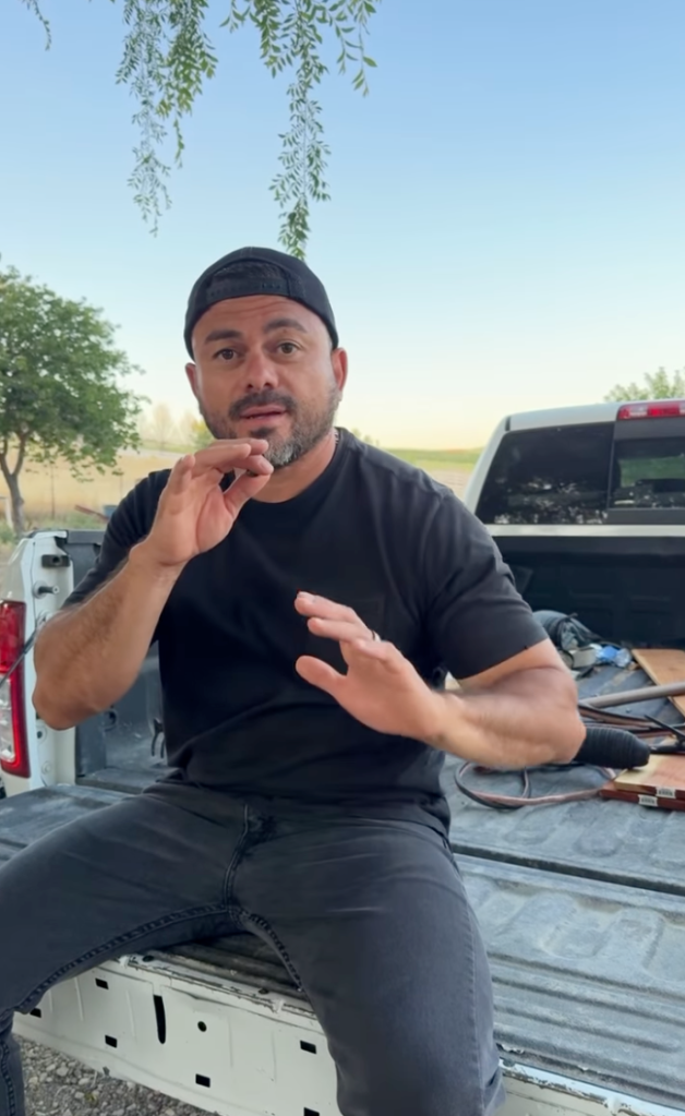 Marco Caracas talking and gesturing while sitting on the tailgate of a pickup truck.