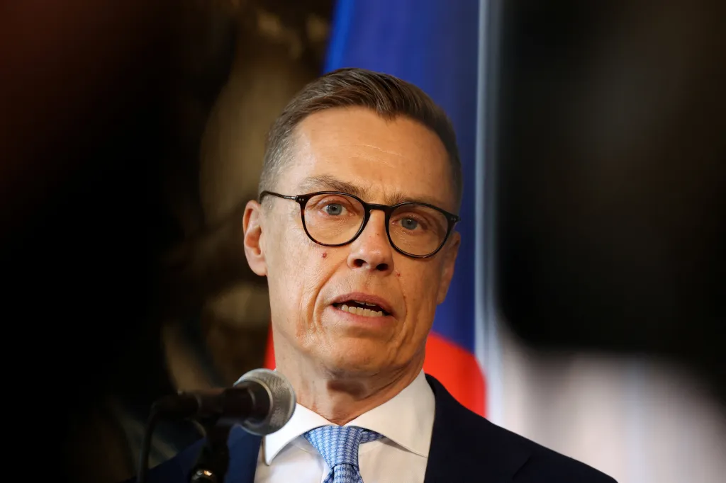 Finnish President Alexander Stubb speaking at a podium in Prague.