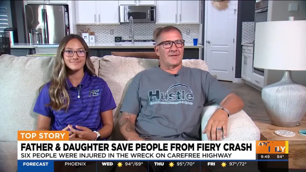 A father and daughter sitting on a couch for an interview about saving people from a fiery car crash.