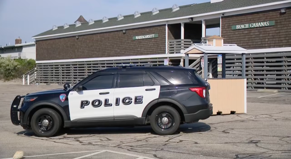 A police car sits parked in the parking lot of the Narragansett Town Beach after a reported stabbing earlier in the day.