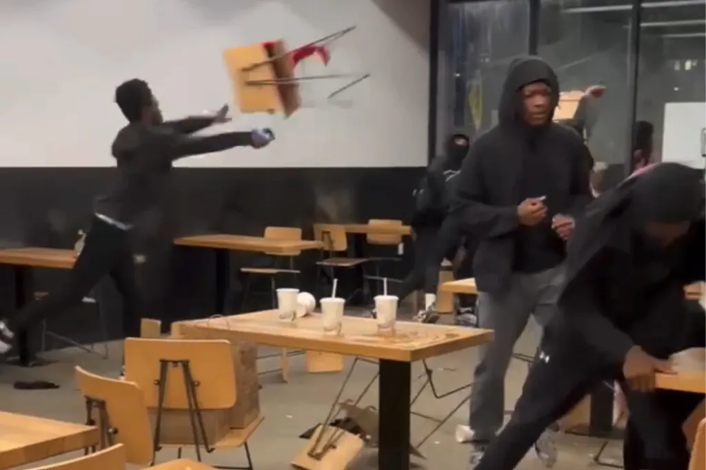 Teenager throwing a chair in a ransacked restaurant, other teens visible in the background.