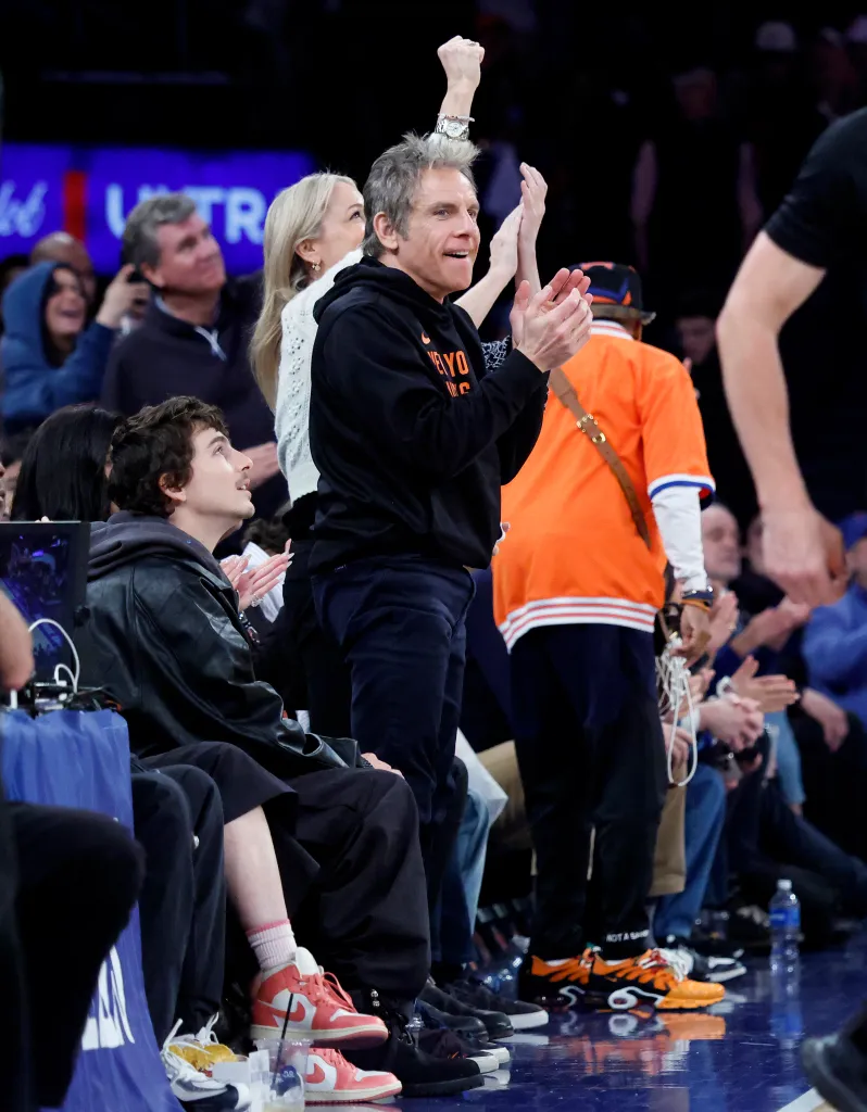 Ben Stiller cheers from celebrity row during an NBA playoffs basketball game.