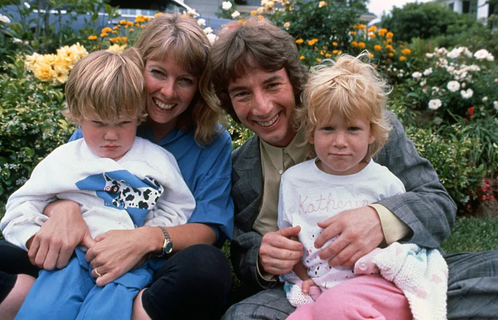 Martin Short and Nancy Dolan smile with their two young children, Katherine Elizabeth and Oliver Patrick, in a garden.