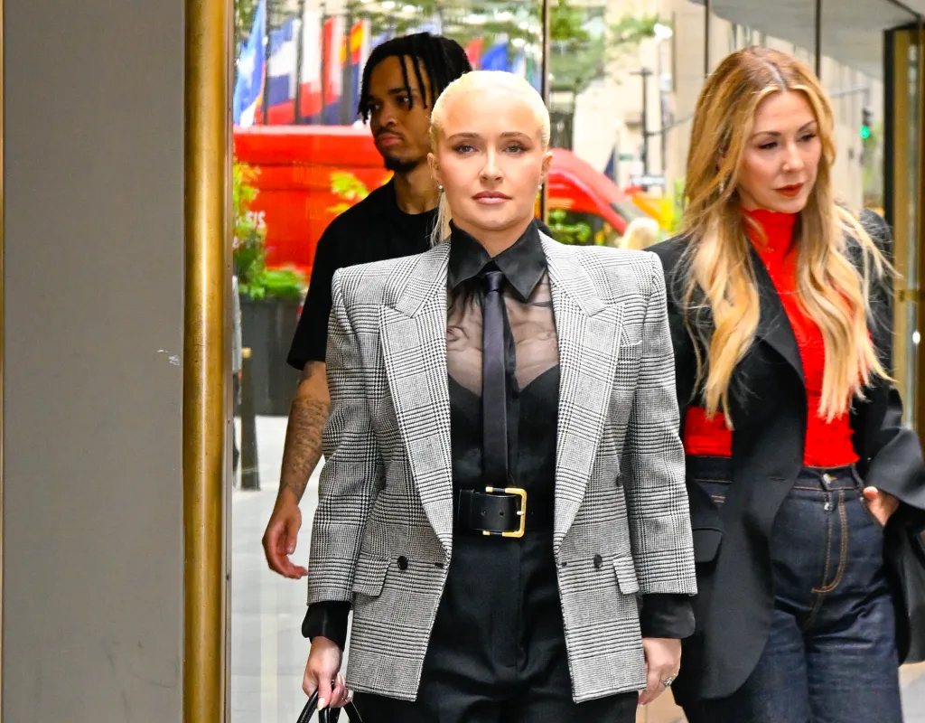 Actress Hayden Panettiere wearing a plaid blazer, black sheer shirt, and tie.
