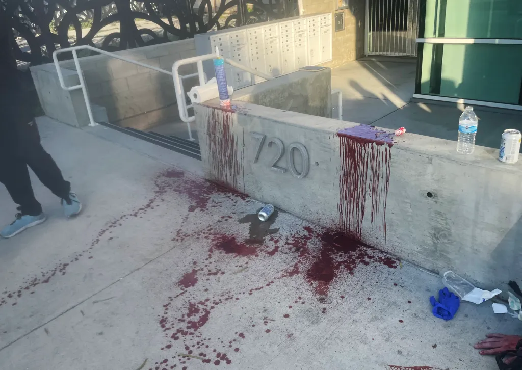 Blood splatter on a concrete wall and sidewalk after a samurai sword attack in Venice.