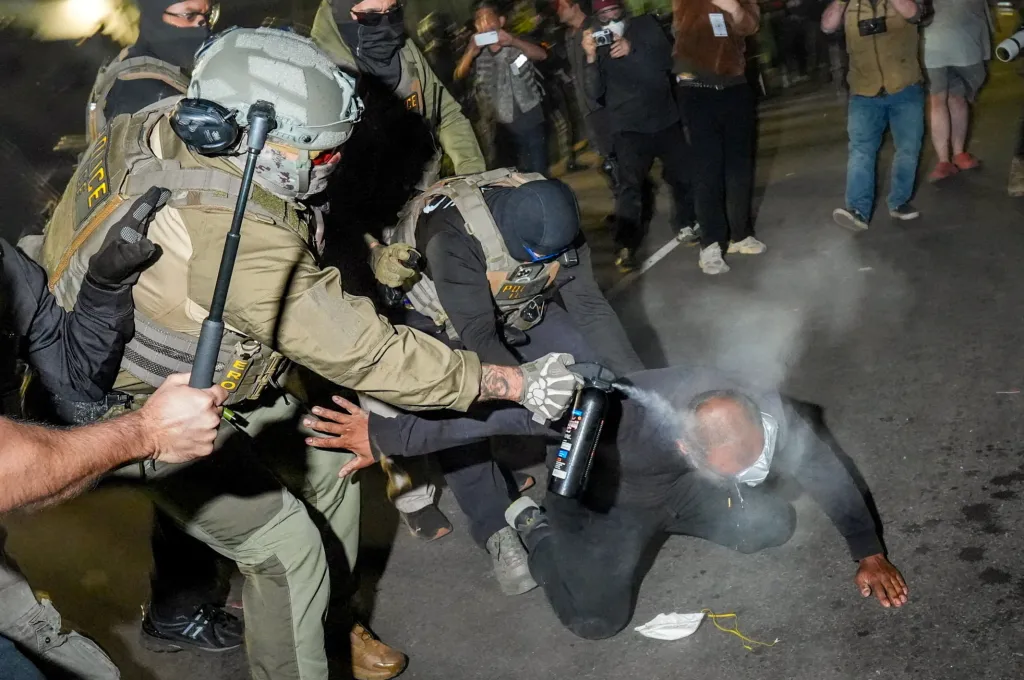 Federal agents take down a protester with pepper spray during a clash outside Delaney Hall on May 28, 2026.
