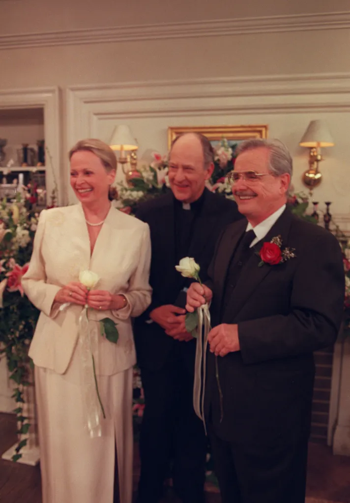 Bonnie Bartlett, Earl Boen, and William Daniels smiling and holding roses.