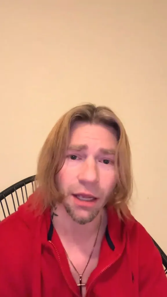 Matt Brown from Alaskan Bush People in a red hoodie and a cross necklace.