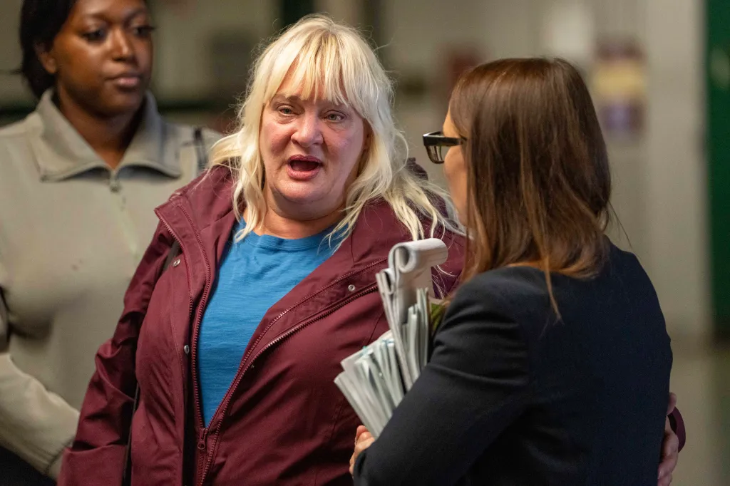 Lisa DeSort in a blue shirt and red sweatshirt in court. 