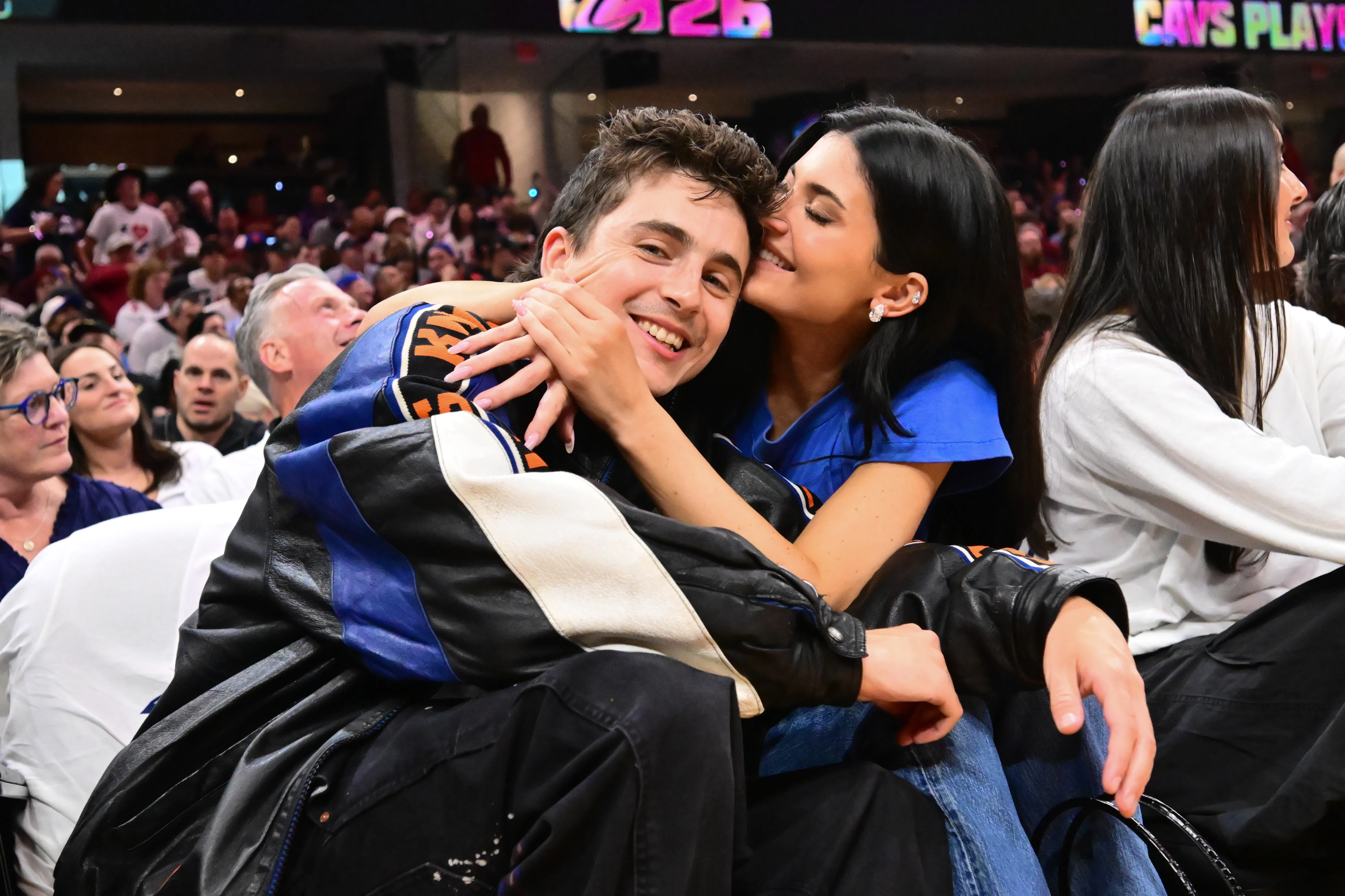 Timothee Chalamet and Kylie Jenner embracing each other at a 2026 NBA playoff game.
