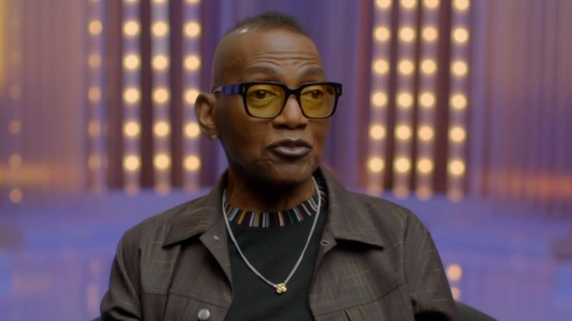 Randy Jackson in an interview, wearing yellow-tinted glasses and a dark jacket.