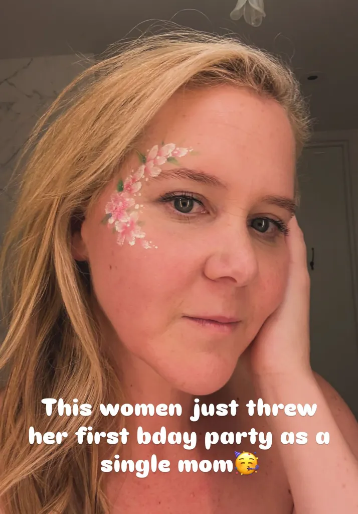 Amy Schumer celebrates a milestone after her split from Chris Fischer, with face paint and the text, 