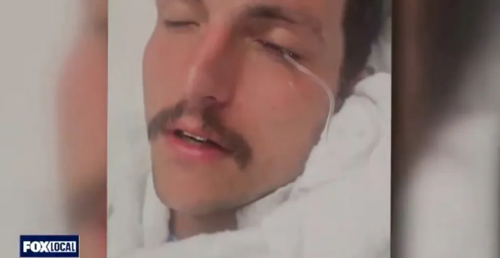 Joe Vallely's eye is being rinsed out with a tube after being pepper-sprayed.