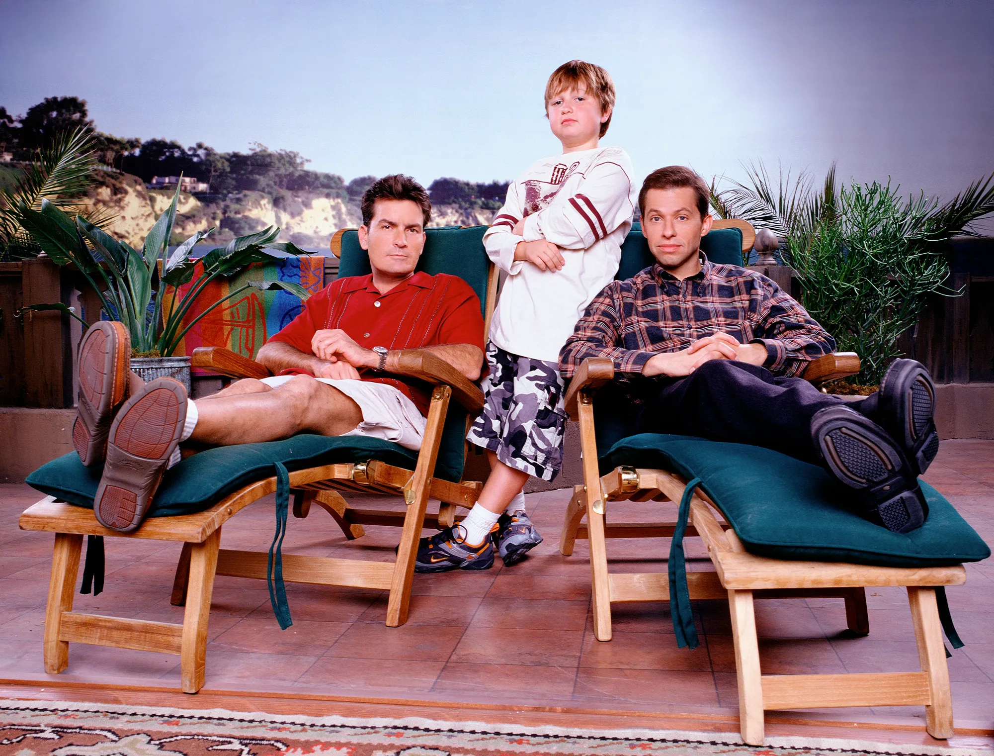 Charlie Sheen, Angus T. Jones, and Jon Cryer from the television show Two and a Half Men, posing in a promotional photo.
